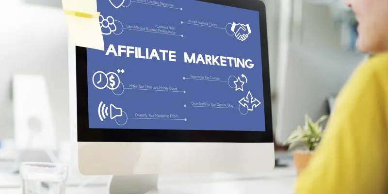 Person setting up a ClickFunnels affiliate marketing program on a desktop computer showing affiliate marketing strategy diagram